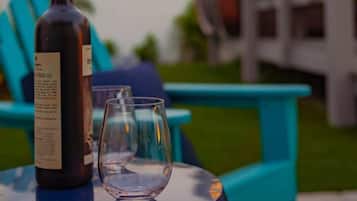 A bottle of wine and an empty glass on a table outdoors.