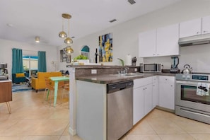A modern kitchen with a dishwasher, microwave, and oven.