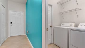 A laundry room with a white door, a washing machine, and a dryer.