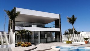 A modern two-story building with large glass windows and a flat roof. - COUNTRY HOUSE LAKE CHAPALA/JOCOTEPEC (JOCOTEPEC)