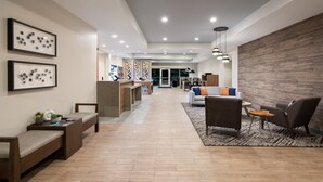 A modern lobby with a reception desk, seating area, and a wooden accent wall.