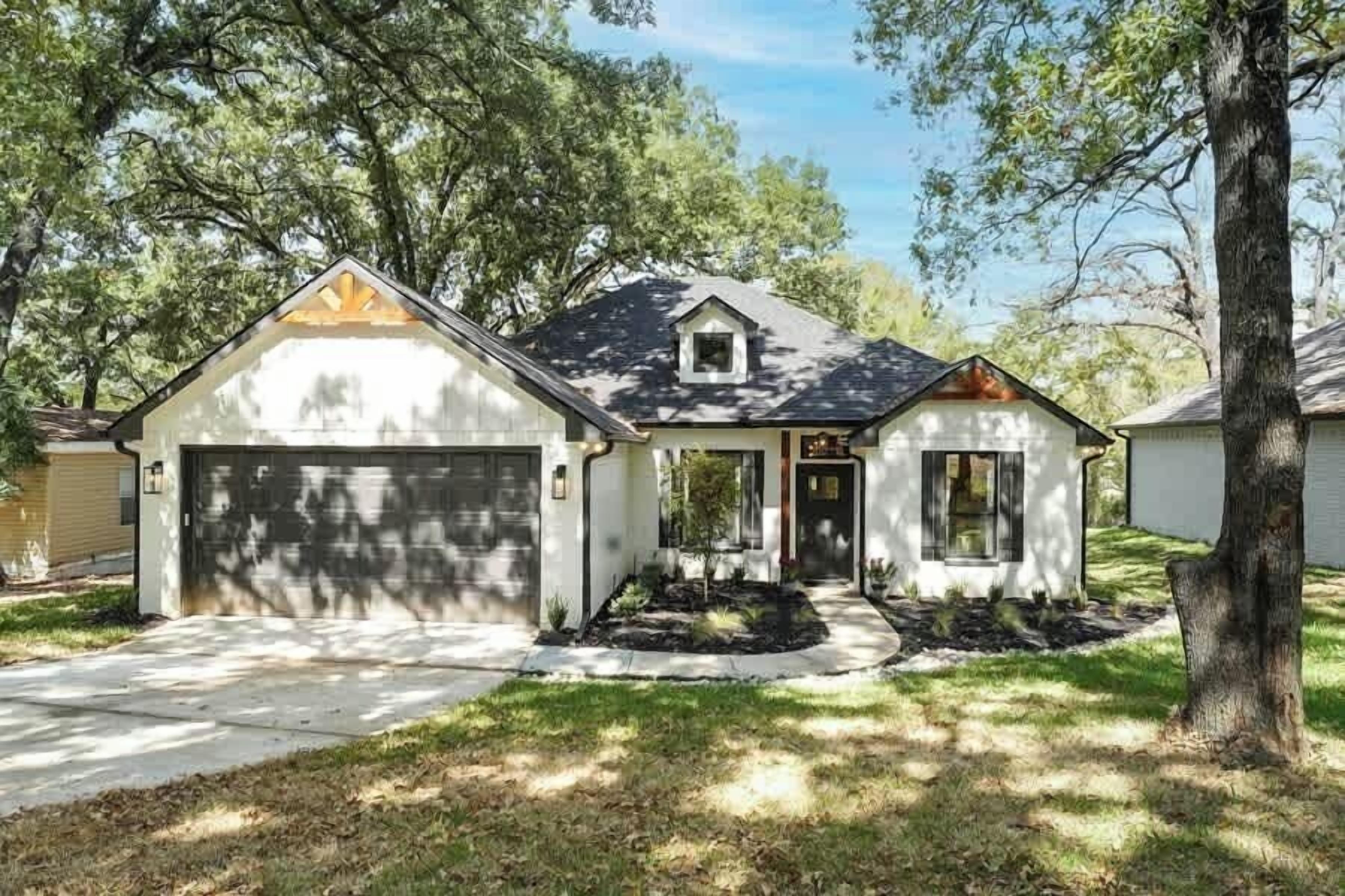 A two-story house with a garage, a front porch, and a small attached shed.