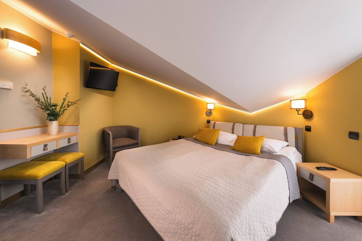 Een moderne hotelkamer met een groot bed, een bureau en een stoel.