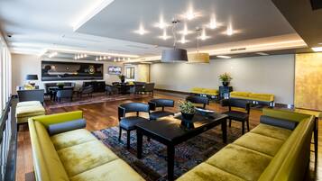 A modern lounge area with sofas, a coffee table, and a TV screen.