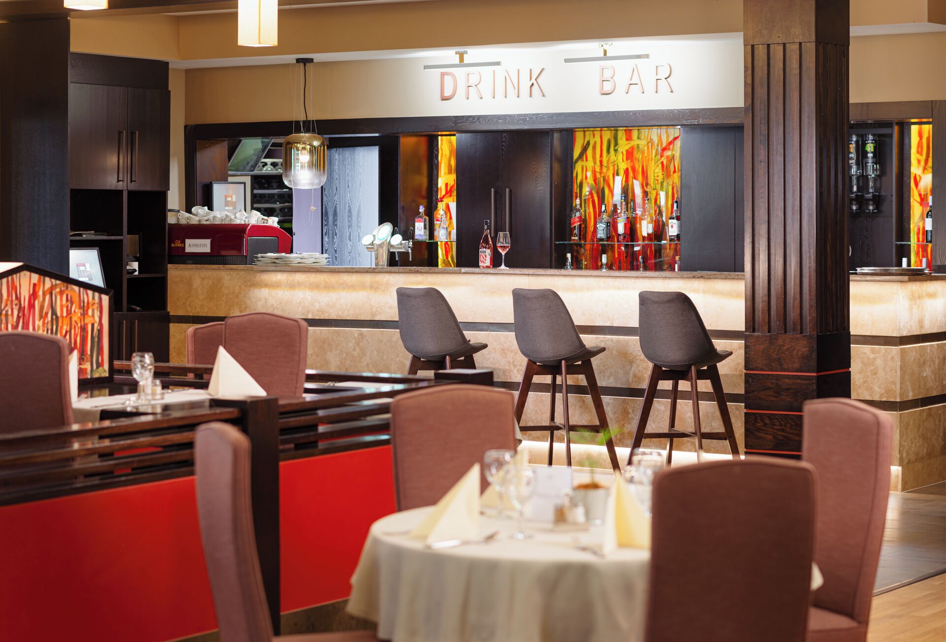 A restaurant with a bar area, bar stools, and a counter with a menu.