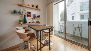 Un comedor moderno con una mesa de madera, sillas acolchadas y estanterías decorativas.
