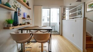 Una cocina moderna con estantes de madera, una mesa de comedor y sillas.