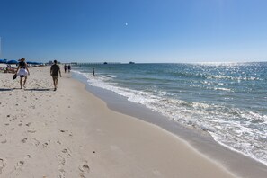 A sandy beach with footprints, a pier in the background, and a clear sky. - GH402- Location X3! OMG View! Adorable, Cozy, Updated, Beach Front Condo! (Gulf Shores)