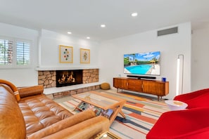 Smart TV, caminetto, libri, impianto stereo