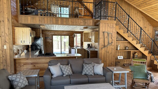 A spacious cabin with a loft bedroom, a dining area, and a kitchen. - Short Drive to Trails, Secluded in the Hiawatha National Forest (Wetmore)