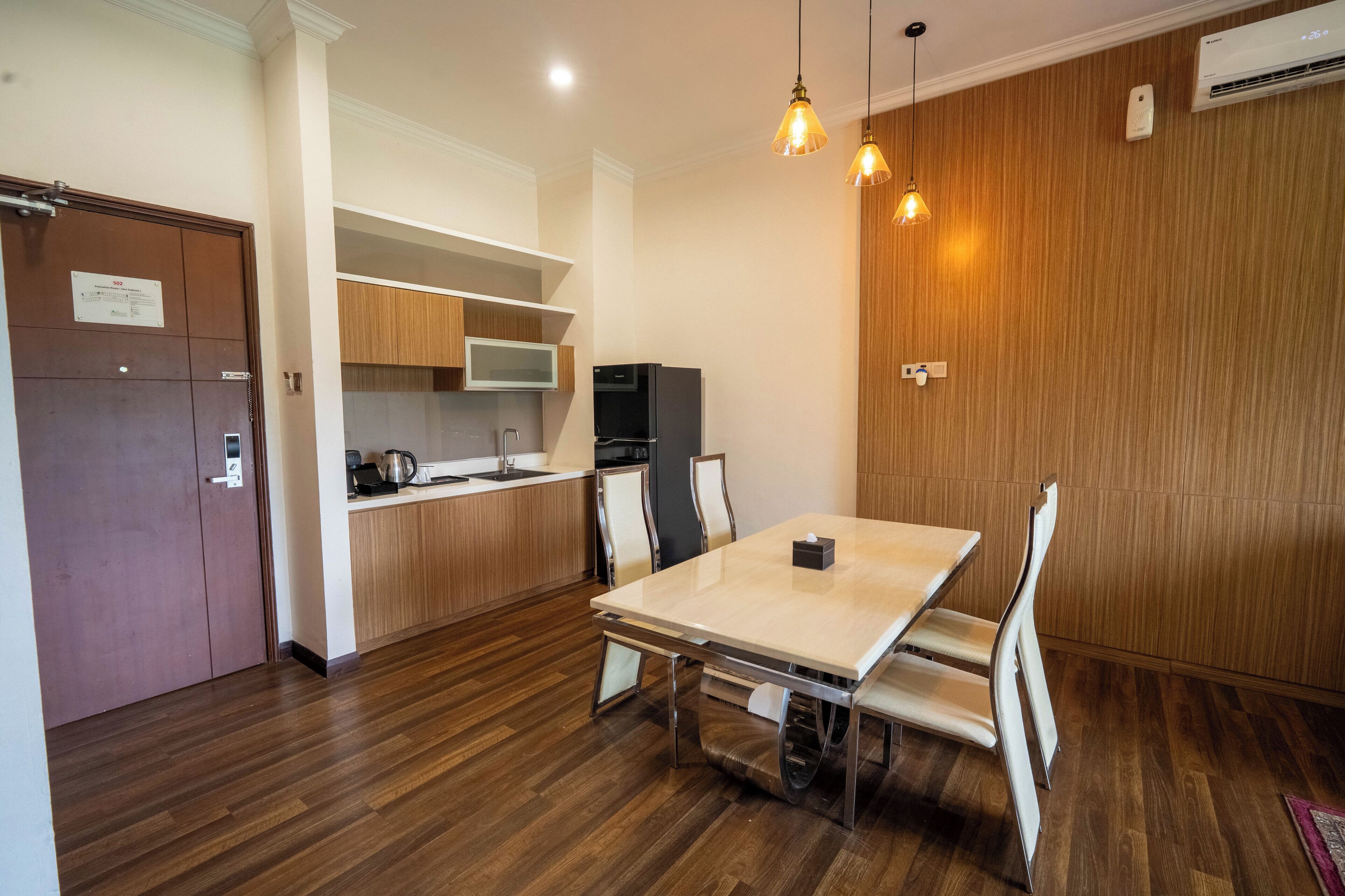 A modern kitchen with wooden cabinets, a refrigerator, and a dining table with chairs.