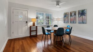 A dining area with a round table, four chairs, a ceiling fan, and a window with blinds. - Arlington Park House Sarasota Tropical Oasis
Sarasota cert of reg # VR25-00010 (Sarasota)