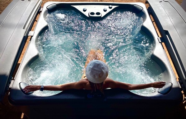 A person in a hot tub with a headrest, surrounded by water jets. - koolkondo Springwater 2 bedroom Oceanfront home (Koloa)