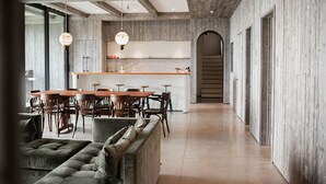 Cocina moderna con encimeras de madera y una isla central, flanqueada por sillas de comedor y un sofá.