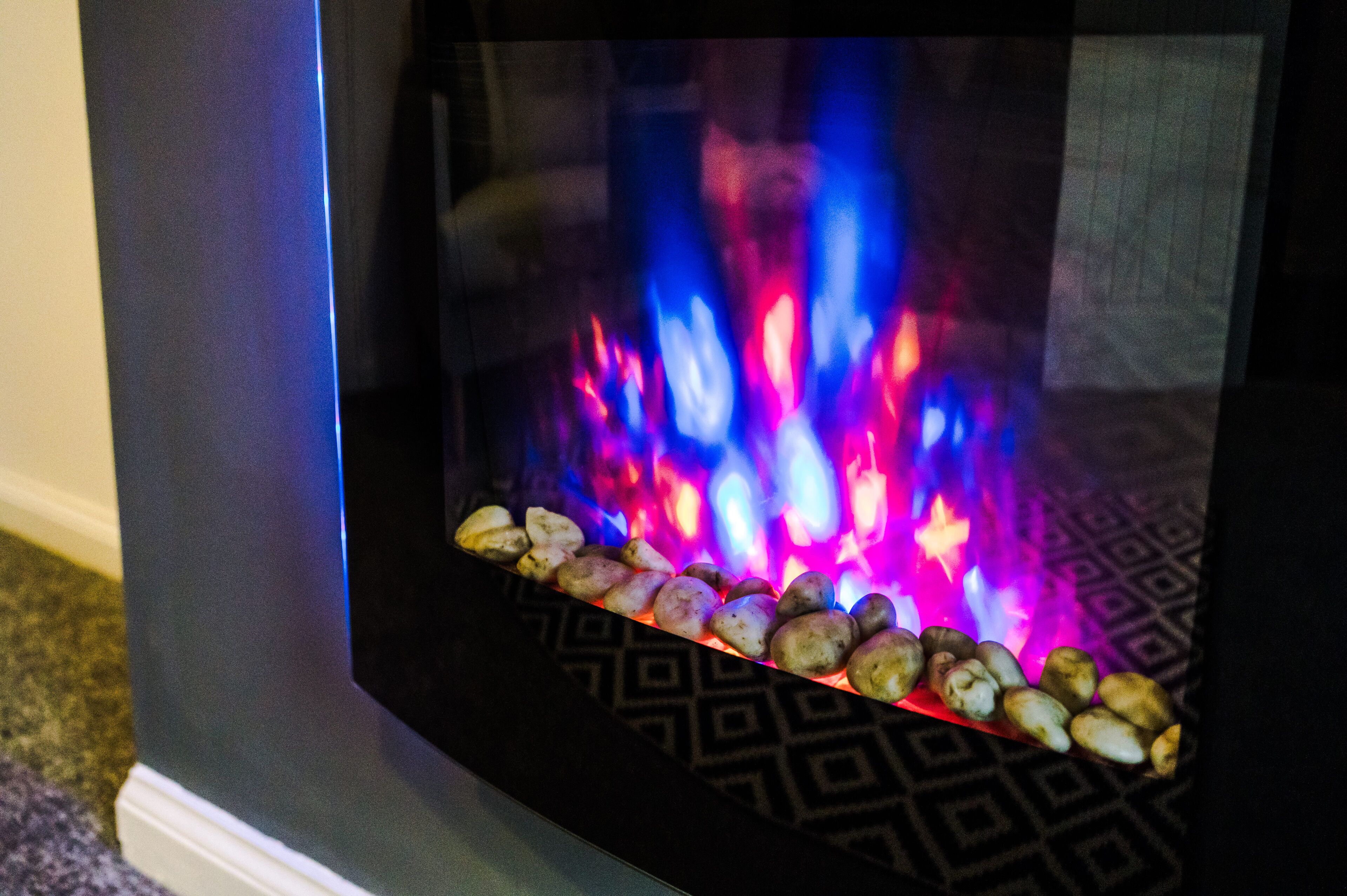 Una chimenea con llamas coloridas y una hilera de piedras.
