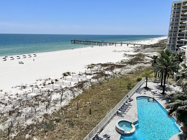 A resort with a pool, beach, and a pier.