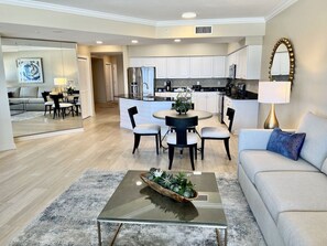 A modern living room with a sofa, coffee table, and dining area.