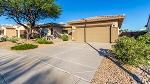 A residential property with a garage, a driveway, and a landscaped garden.