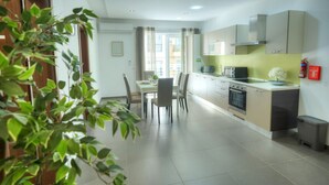 Eine moderne Küche mit Essbereich, ausgestattet mit einem großen Fenster, einer Spüle und einer Mikrowelle.