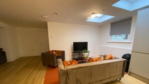 Un salon moderne avec un canapé, une table basse et un téléviseur.