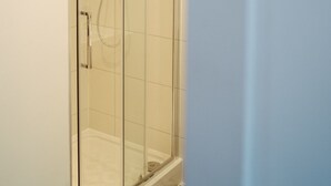 A glass-enclosed shower with a handheld showerhead and a wall-mounted faucet. - Apartment 3 (1 bedroom, sleeps x 4) (York)