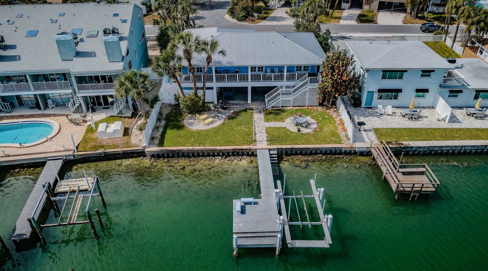 A residential property with a swimming pool, a dock, and a small boat.