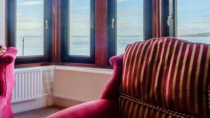 A room with a large window, a radiator, and a striped chair. - The Old Nunnery - UK7122 (Skelmorlie, near Largs)