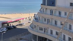 Et hotel med flere etager, med altaner med udsigt over en strand og havet.