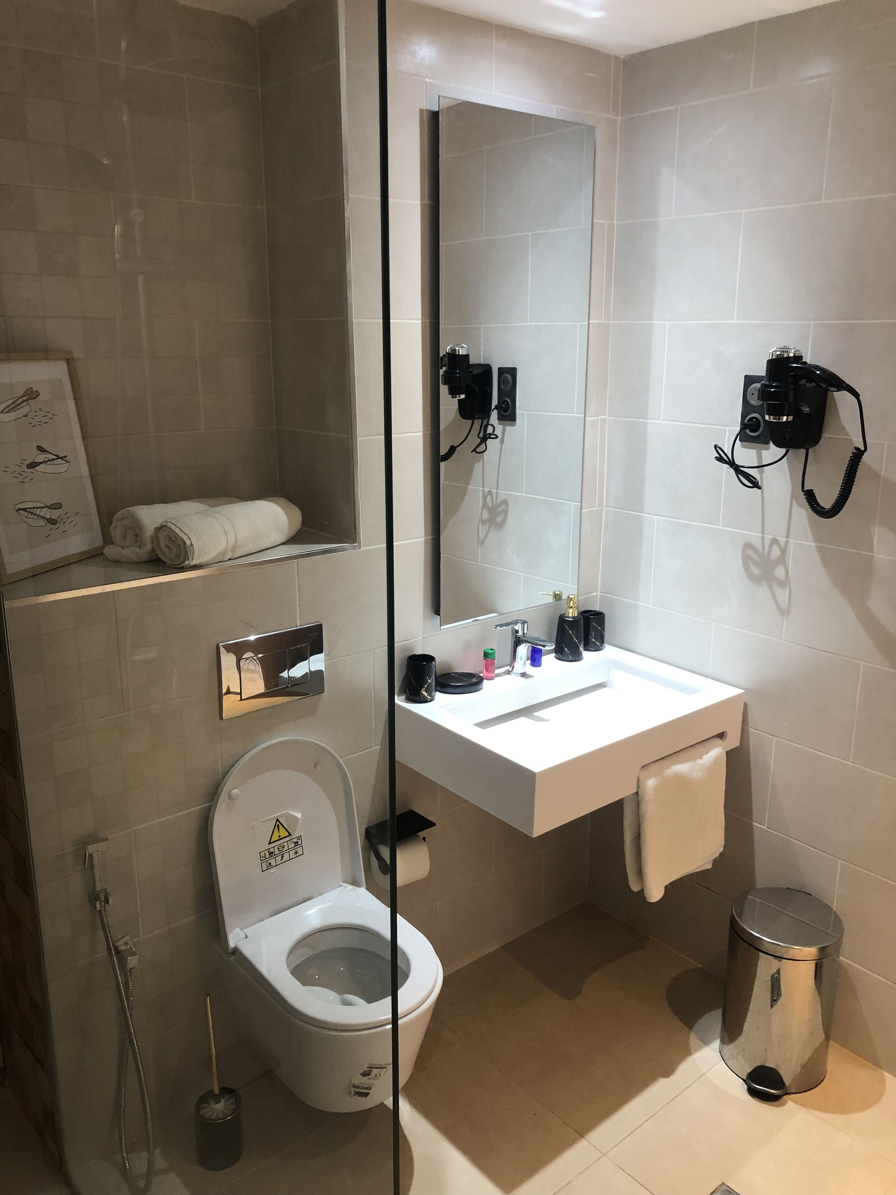 A modern bathroom with a toilet, sink, and shower.