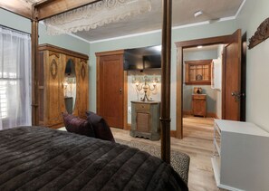 A bedroom with a four-poster bed, wooden wardrobe, and a small table with a lamp. - Historic River Front Farmhouse Near Wineries-Private waterfront! Winery tour! (Prosser)
