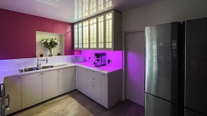 Una cocina moderna con un ventanal amplio, horno empotrado y refrigerador.