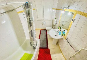 Een badkamer met een bad, toilet en wastafel.