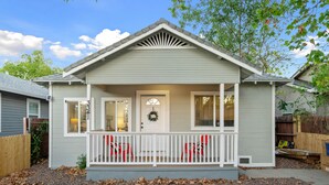 A single-story house with a front porch, a door with a wreath, and a small window.