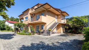A two-story house with a balcony, a staircase, and a garden with flowers. - Stunning apartment in Spincici with WiFi (Spincici)