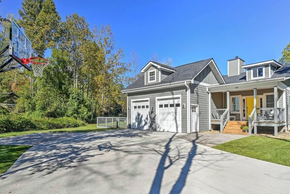 A residential house with a garage, a covered porch, and a basketball hoop.