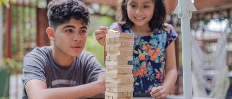 Two people playing a wooden block game at a table.