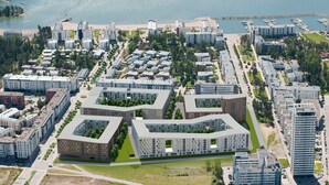An aerial view of a modern residential area with multiple apartment buildings, a marina, and a beach. - Nice apartment with sea view<br> (Helsinki)
