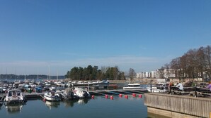 A marina with multiple boats docked, a wooden dock, and a row of buildings in the background. - Nice apartment with sea view<br> (Helsinki)