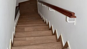 Un escalier en bois avec des rampes blanches et un cadre photo accroché au mur.