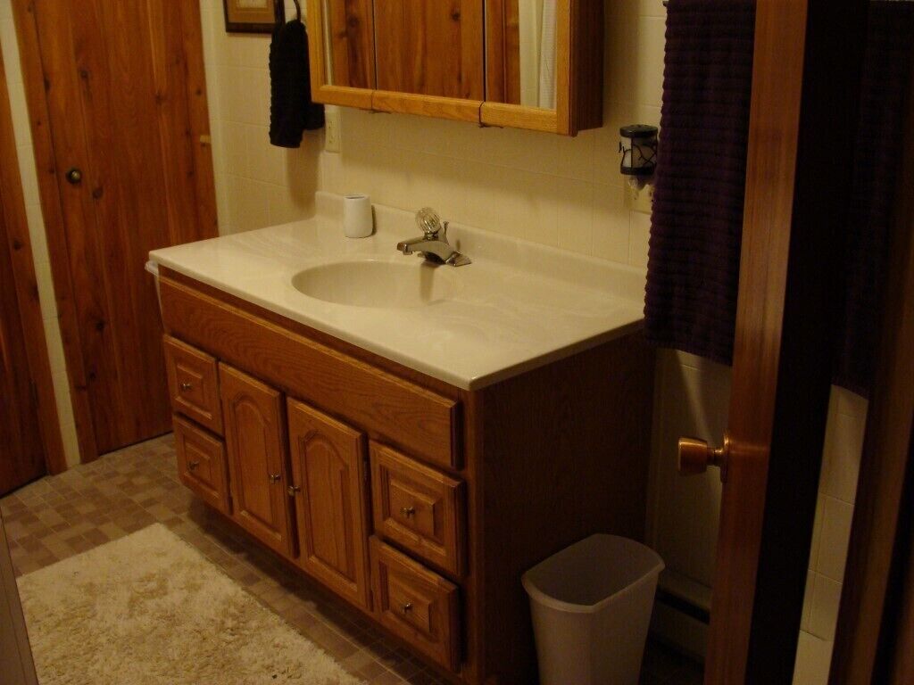 Un bagno con un mobile bagno in legno, un lavandino e uno specchio.