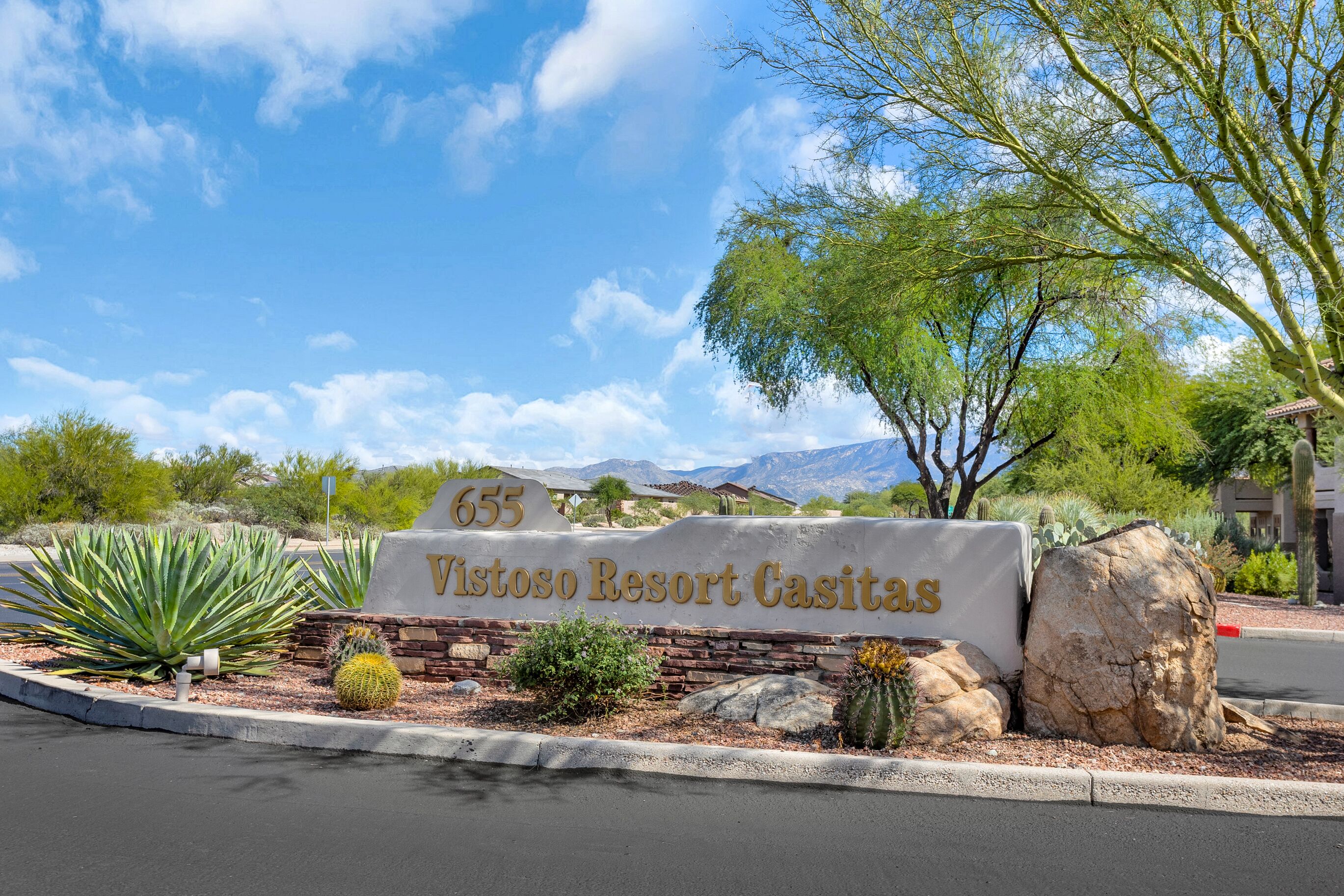 A sign for Vistoso Resort Casitas with a desert landscape in the background.