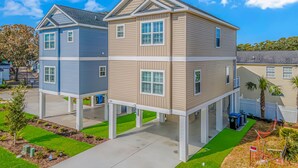A two-story residential building with a flat roof and a front porch.