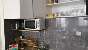 Une cuisine moderne équipée d’un four à micro-ondes, d’une machine à café et d’un meuble à bouteilles.