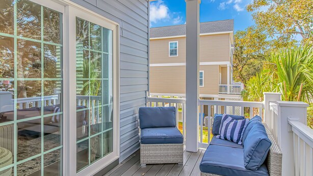A covered porch with wicker furniture and a view of neighboring houses. - PRIVATE HOT TUB, steps from the beach, boardwalk and many other attractions. (Myrtle Beach)