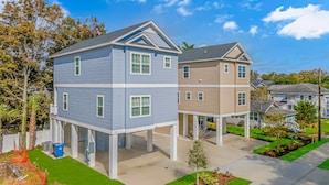 A two-story residential building with a flat roof and a balcony on the second floor. - PRIVATE HOT TUB, steps from the beach, boardwalk and many other attractions. (Myrtle Beach)