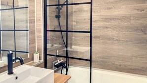 A modern bathroom with a wooden floor, a glass shower enclosure, a white sink, and a mirror. - Studio cabin   4 People  Resort center   Parking (VALLOIRE)