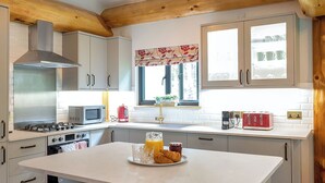 Eine Küche mit einer zentralen Kochinsel, einer Mikrowelle, einem Toaster und einem Gasherd.