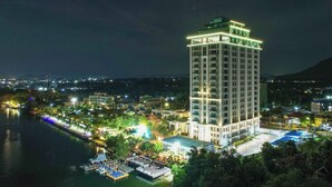 Un hotel moderno de gran altura cerca de un muelle con barcos.