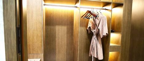 A walk-in closet with wooden paneling, a robe hanging on a rack, and a pair of shoes on the floor.