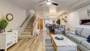 A spacious living room with a staircase, a dining area, and a kitchen in the background. - Lakefront Luxury 212 · Lakefront Luxury for Families or Couples (Wisconsin Dells)